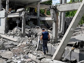A rescuer walks among ruins of a school in Kharkiv, partially destroyed by a rocket on June 2, 2022 as Russian forces are solidifying their hold on the eastern Donbas region and pushing steadily towards Ukraine's de facto administrative centre in that region, Kramatorsk.