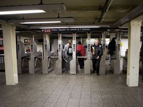 Commuters enter and exit the 42nd Street subway station in New York, U.S., on Thursday, Nov. 20, 2008.