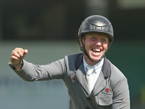 British rider Matt Sampson celebrates his victory during the RBC Grand Prix at the Spruce Meadows National show-jumping tournament in Calgary on Saturday.
