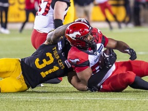 Calgary Stampeders’ Jameer Thurman intercepts the ball intended for Hamilton Tiger-Cats’ Sean Thomas Erlington to win the game in overtime in Hamilton on June 18, 2022.