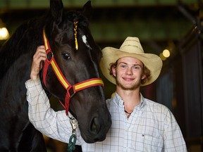 Chance Bell poses for a photo with Fancy Toes at the draft horse barn on the Stampede grounds on Friday, July 8, 2022.