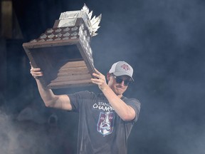 Cale Makar #8 of the Colorado Avalanche holds up a the Conn Smythe Trophy while on-stage during the Colorado Avalanche Victory Parade and Rally at Civic Center Park on June 30, 2022 in Denver, Colorado.