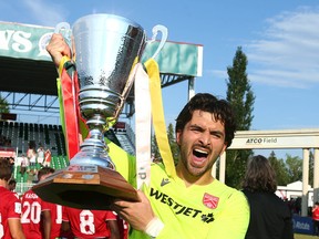 Cavalry FC goalkeeper Marco Carducci lifts the Wild Rose Cup following their victory over FC Edmonton on ATCO Field at Spruce Meadows on Saturday, July 30, 2022.