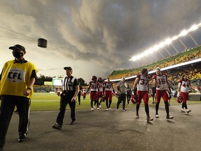The Calgary Stampeders and Edmonton Elks leave the field for a lightning delay during the second half of their game at Commonwealth Stadium in Edmonton on Thursday, July 7, 2022.