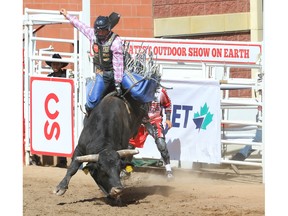 Clayton Sellars hangs on tight for an 88.5 on a bull named Afraid To Nod during the bull-riding event at the Calgary Stampede rodeo on Sunday, July 10, 2022.