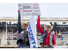 Shane Proctor of Grand Coulee, Washington, left, and Dakota Buttar from Eatonia, Saskatchewan, tied for the win in Bull Riding at the Calgary Stampede Rodeo in Calgary, Ab., on Sunday, July 17, 2022. Mike Drew/Postmedia