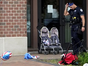 A police officer reacts as he walks in downtown Highland Park, a suburb of Chicago, Monday, July 4, 2022, where a mass shooting took place at a Fourth of July parade.