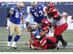 Winnipeg Blue Bombers quarterback Zach Collaros (8) gets sacked by Calgary Stampeders' Mike Rose (41) during the first half of CFL action in Winnipeg, Friday, July 15, 2022.