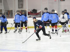 United States hockey player Haley Skarupa, front, demonstrates a drill during a hockey clinic presented by the Washington Capitals and the Professional Women's Hockey Players Association, Friday, March 4, 2022, in Arlington, Va.
