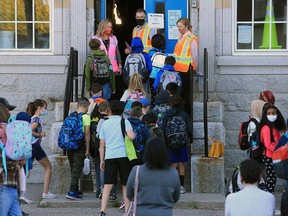 FILE PHOTO: Staff lead students into class at a Calgary elementary school on Sept. 1, 2020.