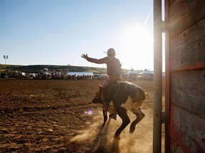 Kaden Piper from Stoughton, Sask., rides his bull at the Writing-On-Stone Rodeo east of Milk River, Ab., on Sunday, July 31, 2022.