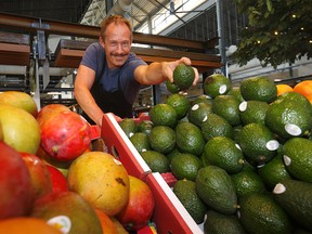 Keith Goodale from Vegetable Butcher fills up the bins during the exclusive opening of the Calgary Farmers' Market's second location, CFM West, located at 25 Greenbriar Drive N.W. in Calgary on Thursday, August 11, 2022.