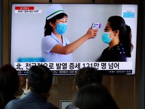 People watch a TV broadcasting a news report on the COVID-19 outbreak in North Korea, at a railway station in Seoul, South Korea, May 17, 2022.