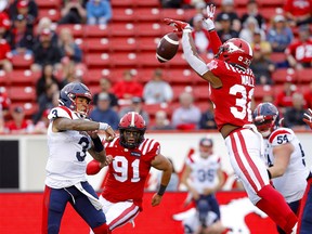 Titus Wall des Stampeders de Calgary bloque le QB Vernon Adams des Alouettes de Montréal.  La passe de Jr. lors de la première mi-temps de la LCF au stade McMahon de Calgary le jeudi 9 juin 2022.