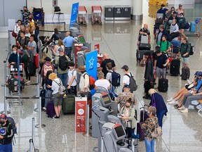 Travellers line up to check in at the Calgary International Airport on Tuesday, Aug. 23, 2022. The federal government has announced close to $2 million in new funding to help the airport recover from the effects of the pandemic.