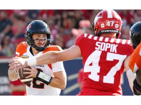 BC Lions quarterback Nathan Rourke looks to avoid  a tackle by Fraser Sopik of the Calgary Stampeders during CFL football in Calgary on Saturday, August 13, 2022. AL CHAREST / POSTMEDIA