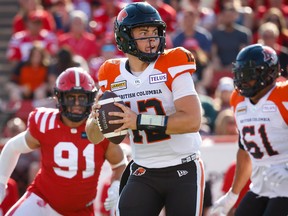 Lions quarterback Nathan Rourke takes off with the ball under pressure from Stampeders defensive lineman Isaac Adeyemi-Berglund on Saturday.