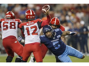 Toronto Argonauts defensive lineman Shane Ray (5) gets a tackle on Calgary Stampeders quarterback Jake Maier (12) as he gets a throw off during second half CFL football action in Toronto on Saturday, August 20, 2022.