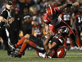 Le joueur de ligne défensive des Stampeders de Calgary Shawn Lemon limoge le quart-arrière du Rouge et Noir d'Ottawa Caleb Evans à la Place TD à Ottawa le vendredi 5 août 2022. Il s'agissait du 82e sac de Lemon en carrière dans la LCF.
