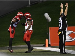 Le demi défensif des Stampeders de Calgary Titus Wall (32) célèbre son touché avec le joueur de ligne défensive Shawn Lemon (40) après avoir intercepté le ballon du quart-arrière des Redblacks d'Ottawa Caleb Evans (5), non montré, lors de la première mi-temps de la LCF à Ottawa le vendredi 28 août. 5, 2022.