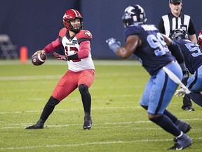 Calgary Stampeders quarterback Jake Maier drops back up to pass against Toronto Argonauts defensive lineman Dewayne Hendrix and defensive lineman Ja’Gared Davis at BMO Field in Toronto on Saturday, Aug. 20, 2022.