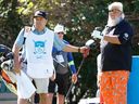 Matt Freeman, head pro at Canyon Meadows Golf and Country Club, caddies for John Daly during the Shaw Charity Classic at Canyon Meadows in Calgary on Friday, Aug. 5, 2022. 