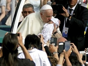 Pope Francis blesses baby Alessia Berrios upon arrival at Commonwealth Stadium to deliver an outdoor mass on Tuesday, July 26, 2022.