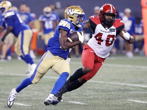 Blue Bombers slotback Greg McRae is chased by Stampeders defensive lineman Shawn Lemon during Thursday's game.