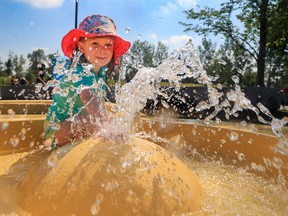 Ava Easthope, 3, cools in the spray at the Prairie Winds Park splash park on Monday, Aug. 22, 2022. Calgary has seen a near record long stretch of hot weather this August.