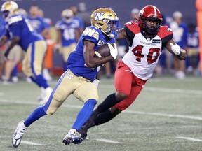 Blue Bombers slotback Greg McRae is being chased by Stampeders defender Shawn Lemon during Thursday's game.
