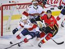 The Calgary Flames' Mark Jankowski and the Florida Panthers' MacKenzie Weegar skid to a stop in front of Panthers goaltender Roberto Luongo during NHL action in Calgary on Saturday February 17, 2018.