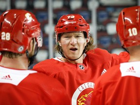 Flames forward Tyler Toffoli chats with Elias Lindholm and Jonathan Huberdeau during training camp in Calgary on Thursday, Sept. 22.