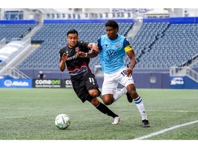 Cavalry FC's José Escalante and HFX Wanderers FC's Andre Rampersad battle for the ball in last year's match in Halifax.