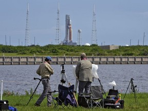 Photographers pack up their equipment as NASA's new moon rocket sits on Launch Pad 39-B after being scrubbed at the Kennedy Space Center,&ampnbsp;in Cape Canaveral, Fla.,&ampnbsp;Saturday, Sept. 3, 2022. Canadian astronaut David Saint-Jacques says the scrubbing of the Artemis moon rocket launch today is disappointing, but necessary.