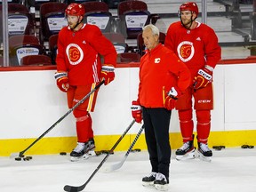 Elias Lindholm, left, with Calgary Flames head coach Darryl Sutter and Jonathan Huberdeau during training camp on Thursday.