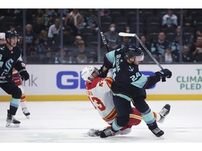 Le défenseur du Kraken de Seattle Jamie Oleksiak et l'attaquant des Flames de Calgary Adam Klapka se sont empêtrés lors de la première période d'un match de hockey préparatoire de la LNH mardi soir à Seattle.