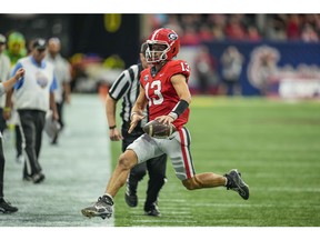 Sep 3, 2022; Atlanta, Georgia, USA; Georgia Bulldogs quarterback Stetson Bennett (13) reaches for a first down as he runs out of bounds against the Oregon Ducks during the first half at Mercedes-Benz Stadium. Mandatory Credit: Dale Zanine-USA TODAY Sports