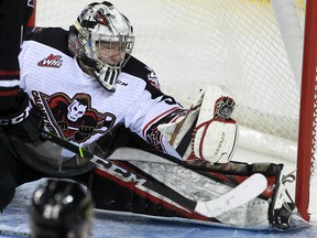 Calgary Hitmen goalie Brayden Peters makes a glove save against the Red Deer Rebels at the Scotiabank Saddledome in Calgary on Oct. 31, 2021.