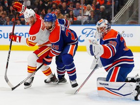 Calgary Flames forward Jonathan Huberdeau (10) and Edmonton Oilers defencemen Darnell Nurse battle in front of goaltender Calvin Pickard at Rogers Place in Edmonton on Friday, Sept. 30, 2022.
