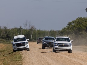 RCMP vehicles drive through James Smith Cree Nation after Myles Sanderson was reportedly sighted on the reserve on Tuesday.