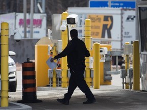 A border officer walks past security cameras at the Thousand Islands border, near Gananoque, Ont., March 16, 2020. The federal privacy watchdog says a data breach at a contractor for Canada's border agency involved as many as 1.38 million licence plate images.