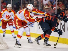 Calgary Wranglers Nicolas Meloche against Coachella Valley Firebirds Andrew Poturalski at Scotiabank Saddledome on Sunday, October 16, 2022. Azin Ghaffari/Postmedia