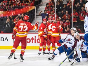 Tyler Toffoli # 73 (L) des Flames de Calgary célèbre avec ses coéquipiers après avoir marqué contre l'Avalanche du Colorado lors d'un match de la LNH au Scotiabank Saddledome le 13 octobre 2022 à Calgary, Alberta, Canada.