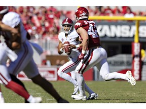 FAYETTEVILLE, ARKANSAS - OCTOBER 01: Bryce Young #9 of the Alabama Crimson Tide rolls out looking for a receiver in the first half and is pressured by Drew Sanders #42 of the Arkansas Razorbacks at Donald W. Reynolds Razorback Stadium on October 01, 2022 in Fayetteville, Arkansas.
