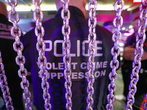 Members of the Calgary Police Violent Crime Suppression Team (formerly the Gang Suppression Unit) are joined by officers as they do a walkthrough at a basement strip club on 7 Ave. SW in downtown Calgary on June 18, 2022.