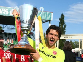 Cavalry FC goalkeeper Marco Carducci lifts the Wild Rose Cup following a win over FC Edmonton on ATCO Field at Spruce Meadows in Calgary on Saturday, July 30, 2022.