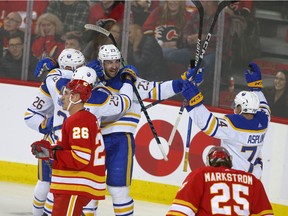 Buffalo Sabres players celebrate one of their three first-period goals against the Calgary Flames at Scotiabank Saddledome in Calgary on Thursday, Oct. 20, 2022.