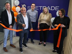 Sidetrade CEO Olivier Novasque cuts the ribbon with employees at the firm’s recently opened Calgary office on Monday, October 3, 2022. The global AI-powered order to cash platform plans to invest $24 million and add 110 full-time jobs in Calgary over the next three years.