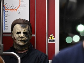 A cosplayer dressed as Michael Myers from the movies "Halloween" rides the trolley during Comic-Con International 2022 on July 21, 2022 in San Diego, California. (Photo by ROBYN BECK/AFP via Getty Images)