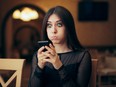 Young woman reacting in disbelief to something on her mobile phone.